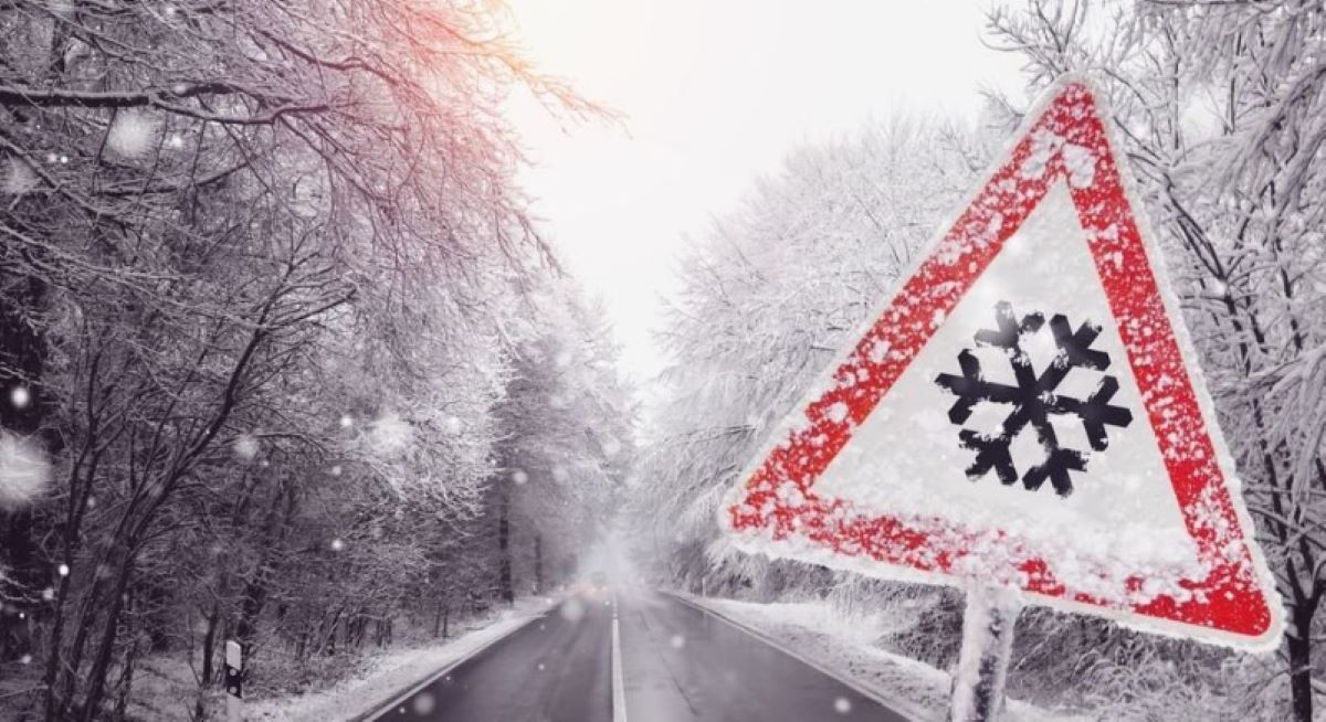 Señal peligro pavimento deslizante por hielo o nieve. Foto de archivo