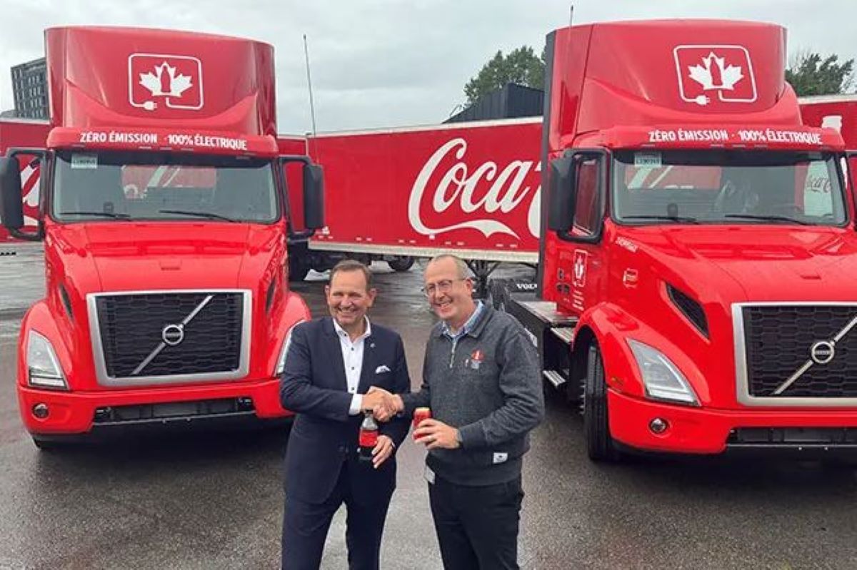 El presidente de Volvo Trucks Norteamérica, Peter Voorhoeve, (izquierda) se une a Stephen du Toit, presidente y director de operaciones de Coca-Cola Canada Bottling Limited (derecha), mientras el fabricante de bebidas recibe los camiones Volvo VNR Electric durante la quinta especial celebración del cumpleaños en el centro de distribución de Coke Canadá en el este de Montreal