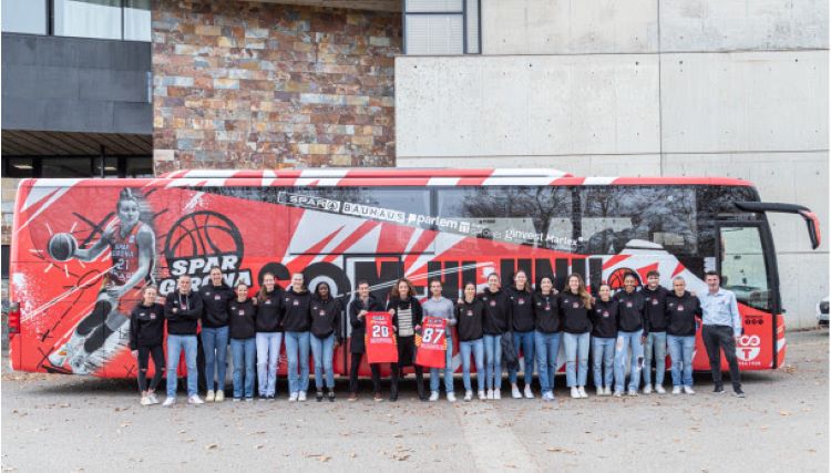 El equipo femenino Uni Girona junto al autobús patrocinado por OnTurtle