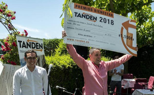 David Abad, trabajador de Tanden transportes, recibe el cheque de 1.100 euros por haber adelgazado 11 kilos en un año. / GABRIEL VILLAMIL