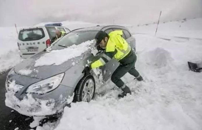 Un agente de la Guardia Civil empujando un vehículo