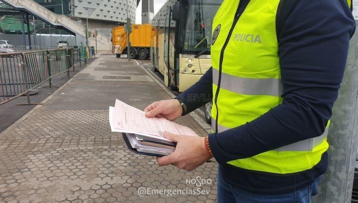 Un agente de la Policía Local al lado de uno de los autobuses denunciados