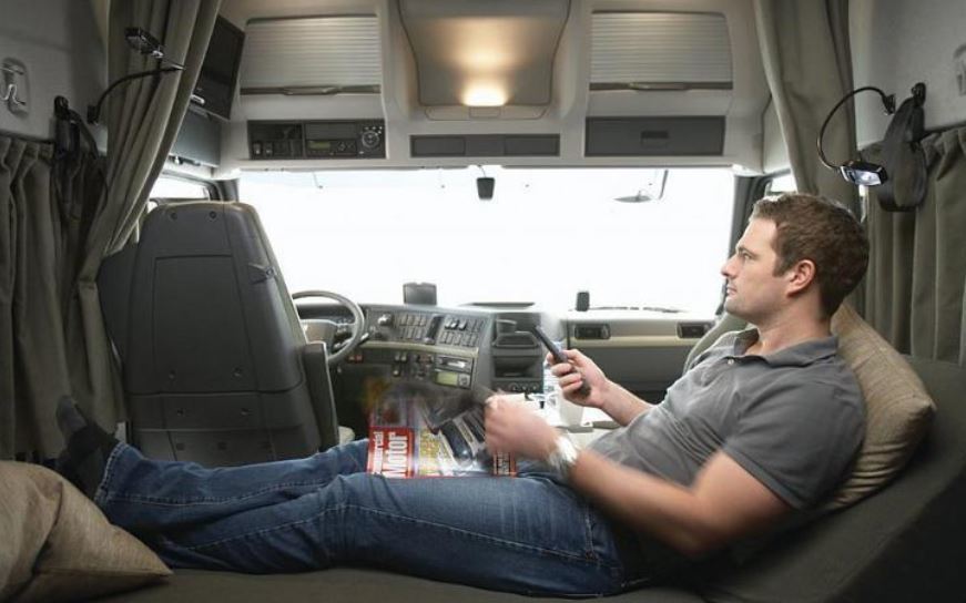 Un camionero descansando en la cabina del camión