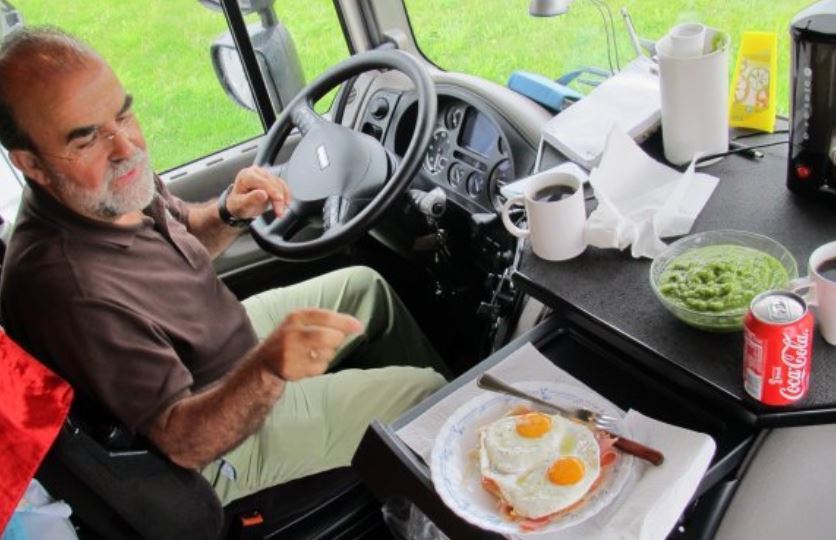 Un camionero comiendo en la cabina