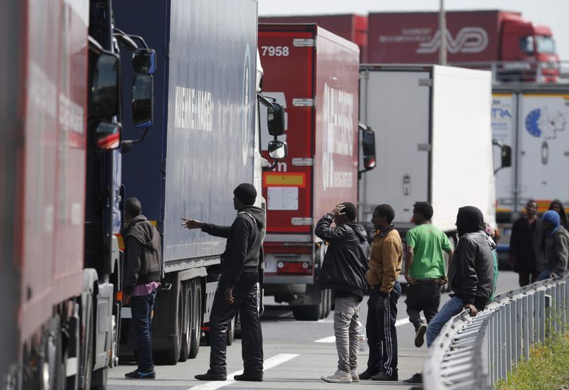 Inmigrantes intentando subir a un camión en Calais