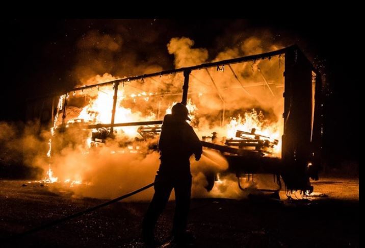 Bomberos apagando el fuego del camión