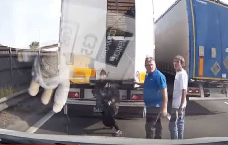 Camionero ayudando a bajar inmigrantes de su camión