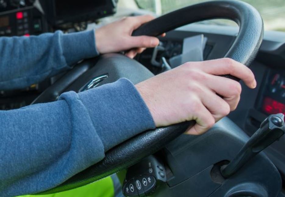 Manos de un joven al volante de un camión