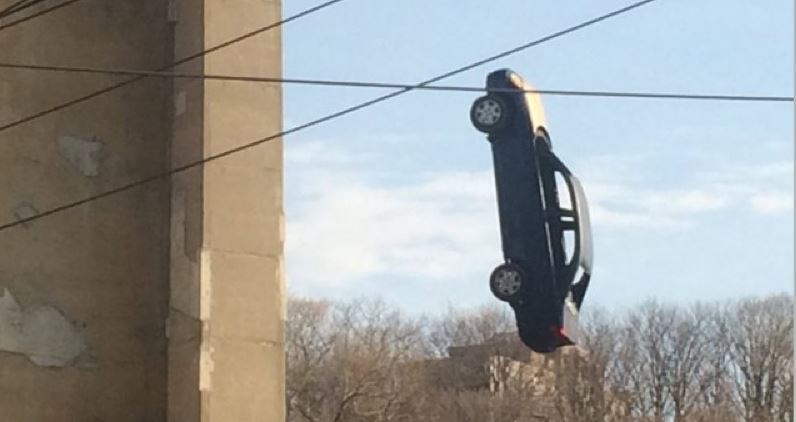 Coche colgando de un puente