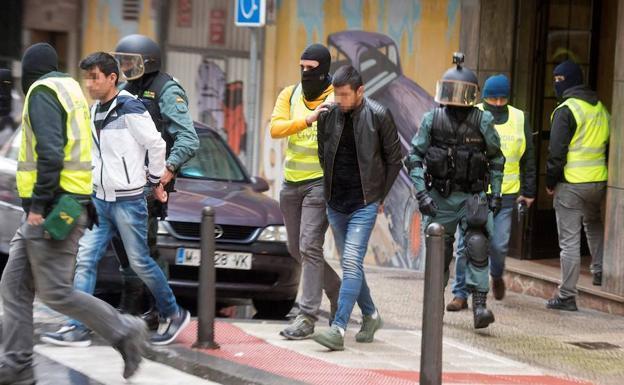Efectivos del instituto armado se llevan a uno de los detenidos en Santander. / EFE