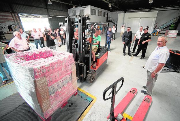 Descarga de los palés de leche, ayer, en la sede del Banco de Alimentos del Segura. / JAVIER CARRIÓN / AGM