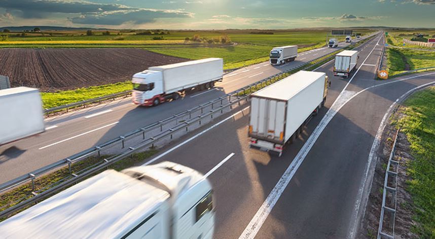 Varios camiones circulando por una carretera