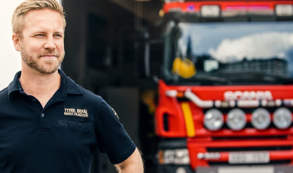 El jefe de bomberos con un camión Scania al fondo