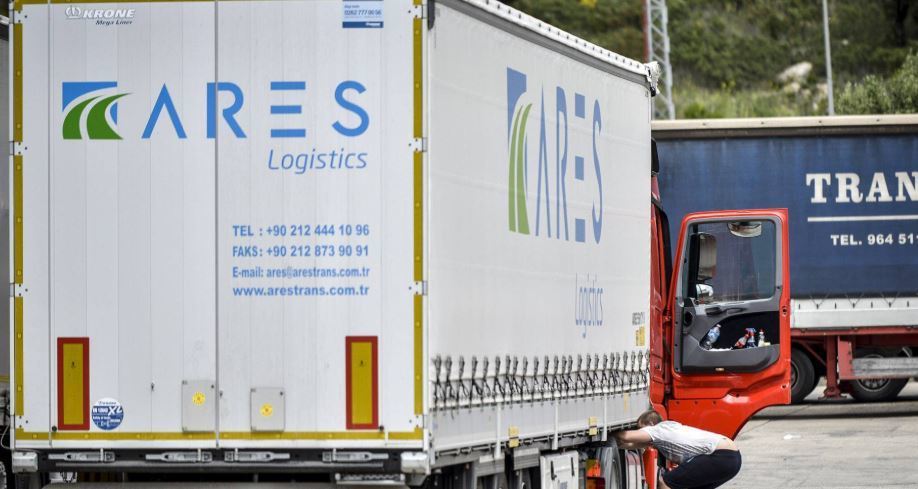 Un camionero revisa los bajos de su vehículo en un estacionamiento de La Jonquera. TONI FERRAGUT