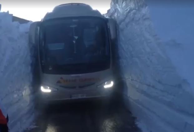 El autobús pasando entre dos paredes de nieve.