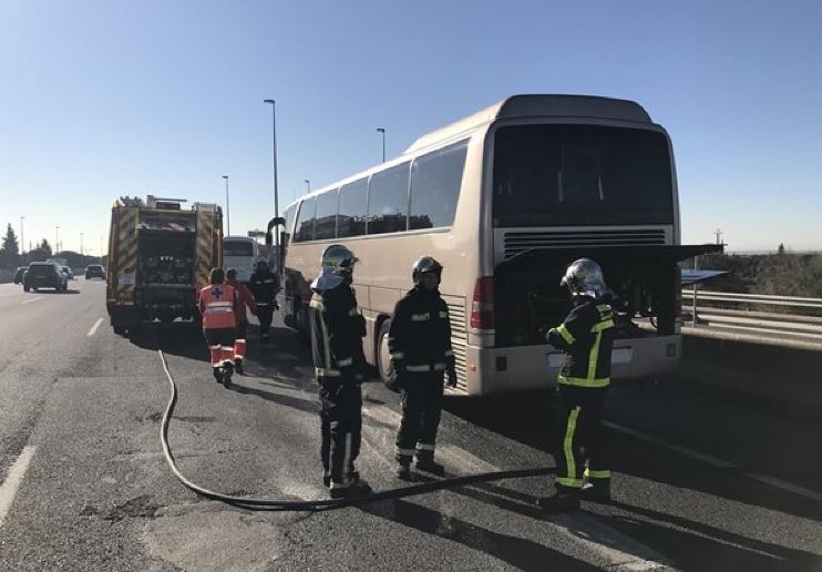 Bomberos trabajando en el lugar del autobús incendiado