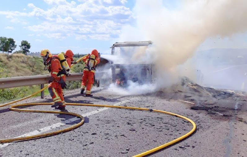 Imagen de los bomberos apagando el fuego del camión