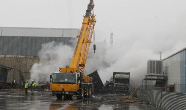 Intervención de los bomberos en la nave de transportes para apagar las llamas que quedaron por la madera y el cartón. / HENAR SASTRE