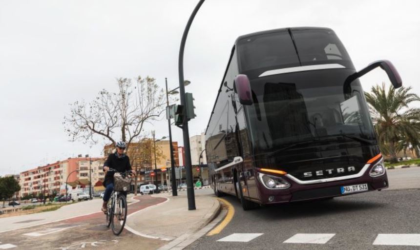 Imagen de un autocar Setra ante un ciclista