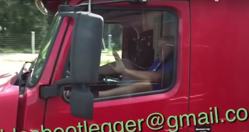 Imagen de un camionero con los pies en el volante