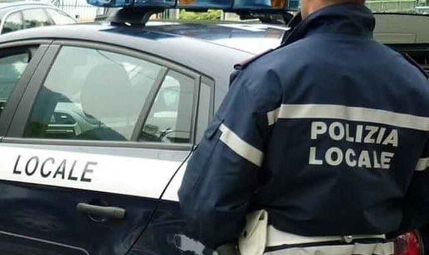 Imagen de un coche patrulla y agente de la policía local de Verona