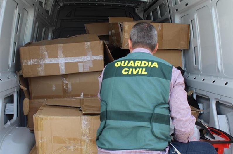 Un agente de la Guardia Civil inspeccionando una furgoneta con ropa robada