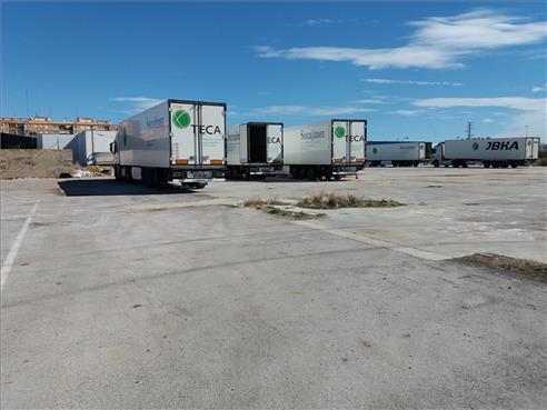 Numerosos vehículos pesados aprovechan este solar pavimentado para aparcar, sin ocupar calles de la ciudad. - Carda