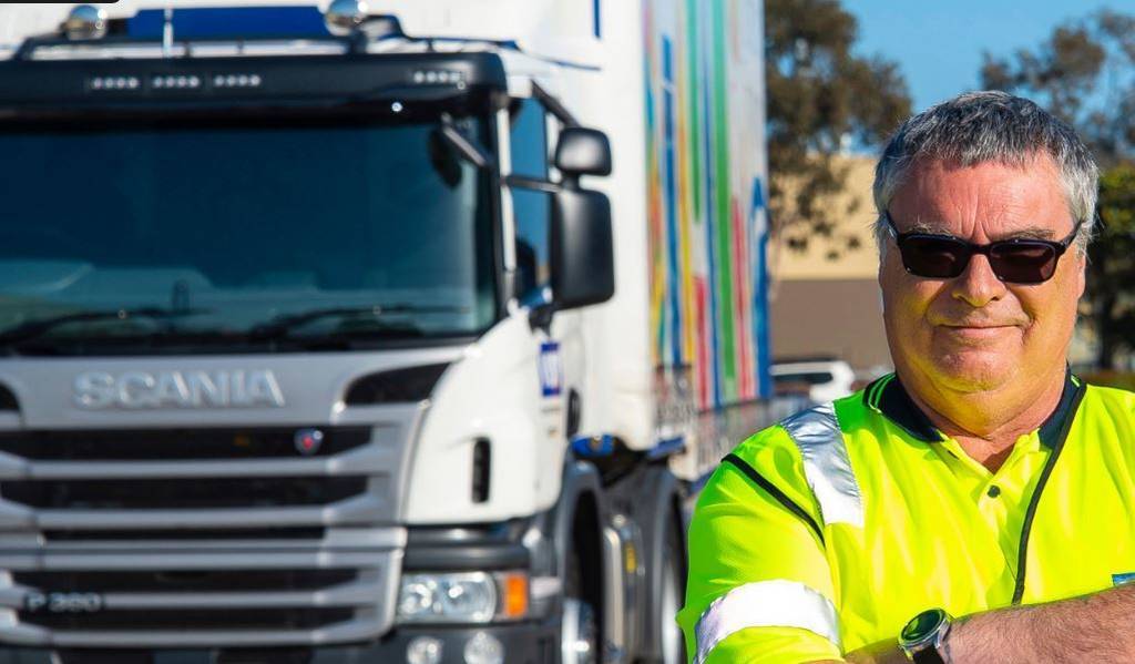 Tim Mason delante de su camión Scania