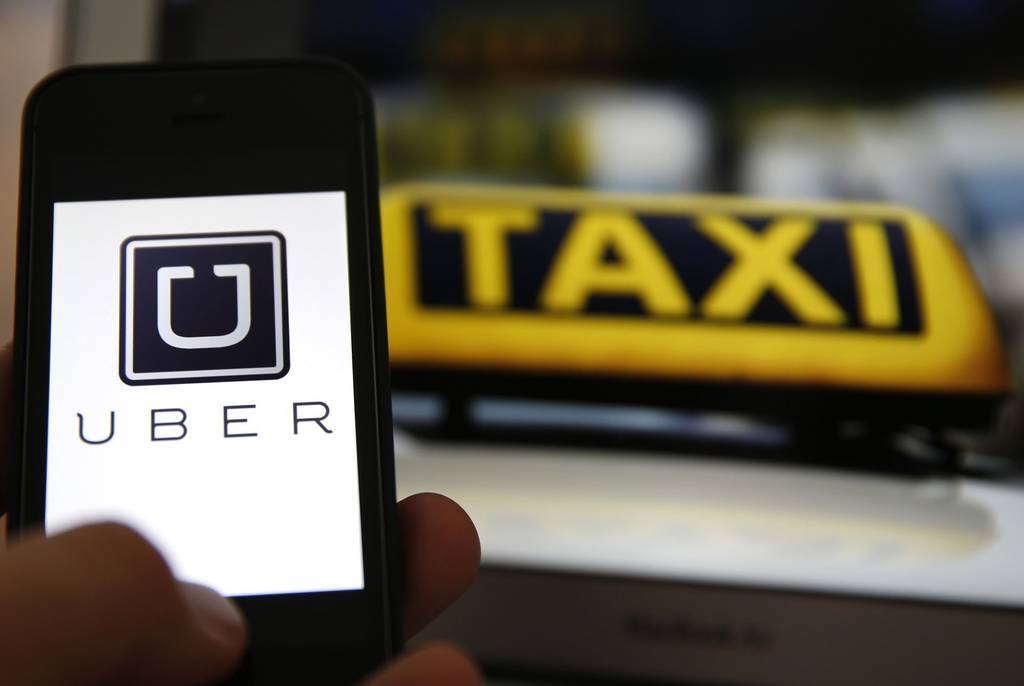 Imagen de la aplicación Uber y de un taxi