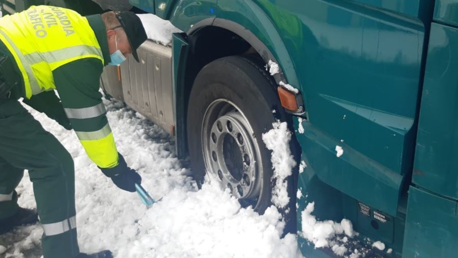 Un Guardia Civil ayudando a un camionero durante el temporal Filomena