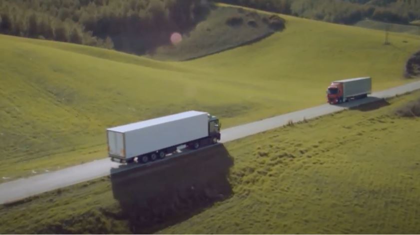 Imagen de dos camiones circulando por una carretera