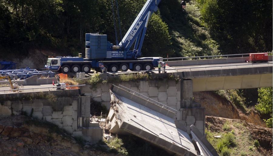 Operarios y grúas trabajan durante el desmontaje del tercer y último vano del viaducto de la A6, en Vega de Valcarce. Foto Europa Press