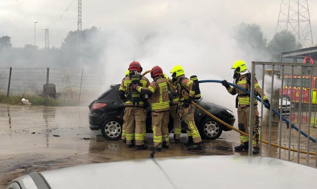 Bomberos apagando el incendio del vehículo