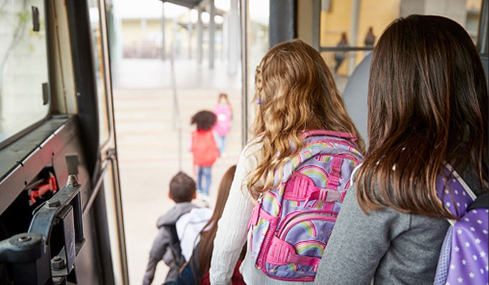 Estudiantes bajando de un autobús escolar