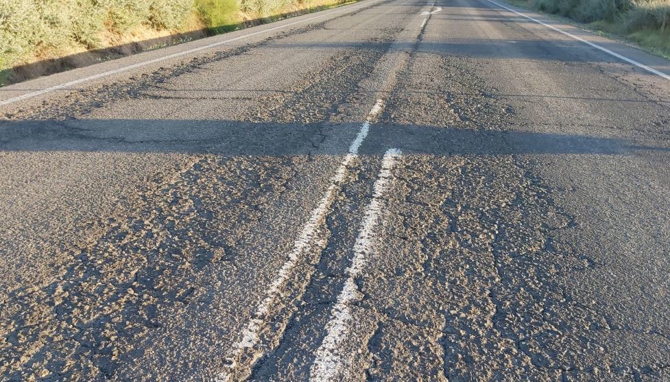 Carretera con roderas profundas, grieta longitudinal y marca vial desgastada
