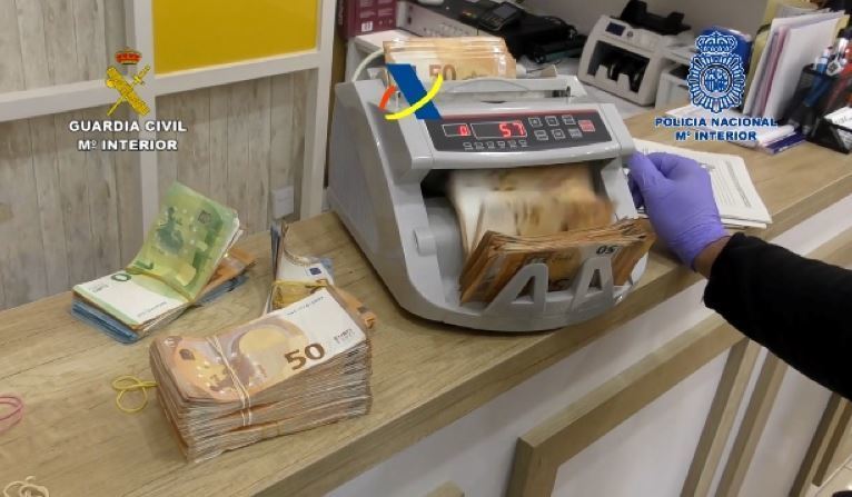 Un agente contando parte del dinero incautado