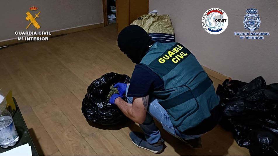 Un agente de la Guardia Civil inspeccionando una bolsa con marihuana
