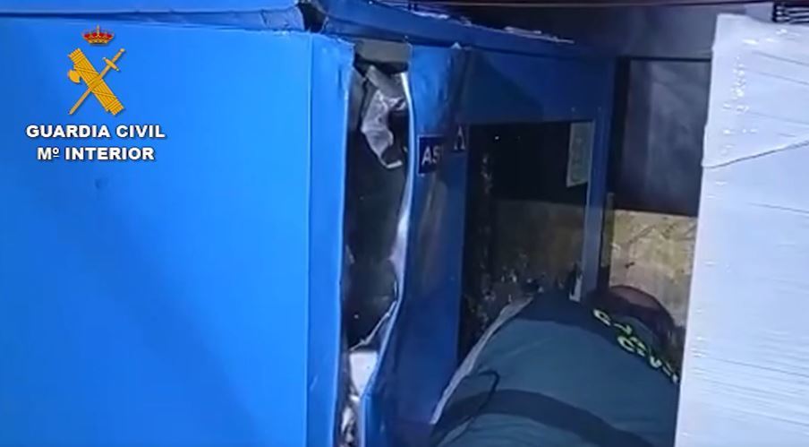 Imagen de un agente localizando la droga en el doble fondo de la mercancía transportada