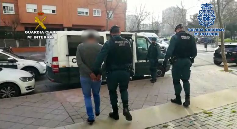 Agentes con uno de los detenidos