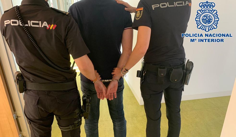 Dos agentes de la policía con el detenido