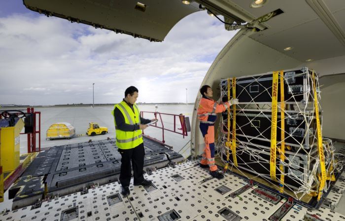 Dos trabajadores descargando mercancía de un avión