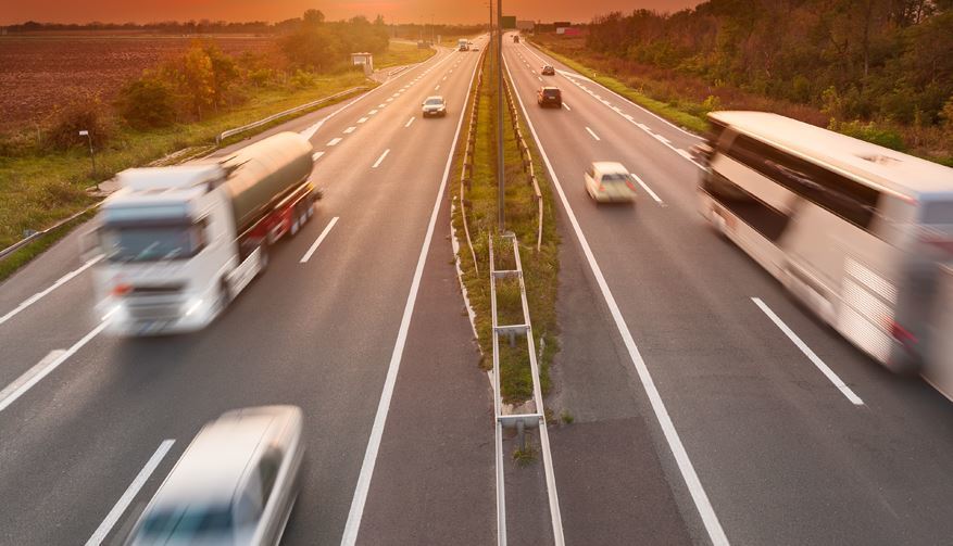 Una carretera con un camión y un autobús