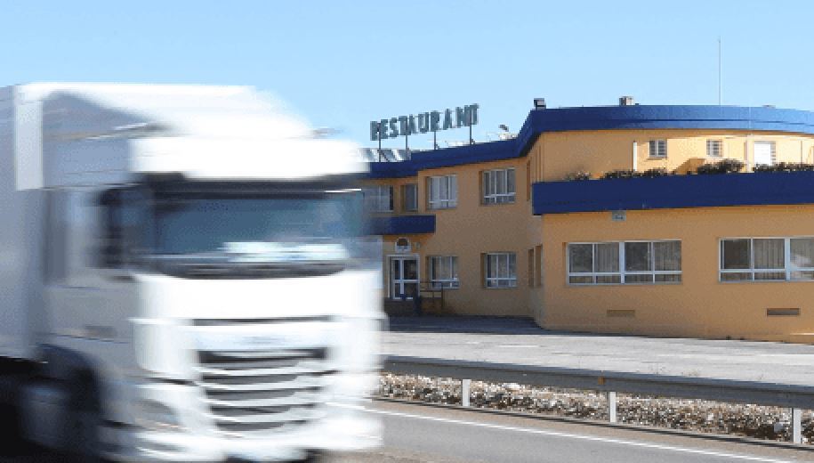 Imagen de un camión pasando por un restaurante