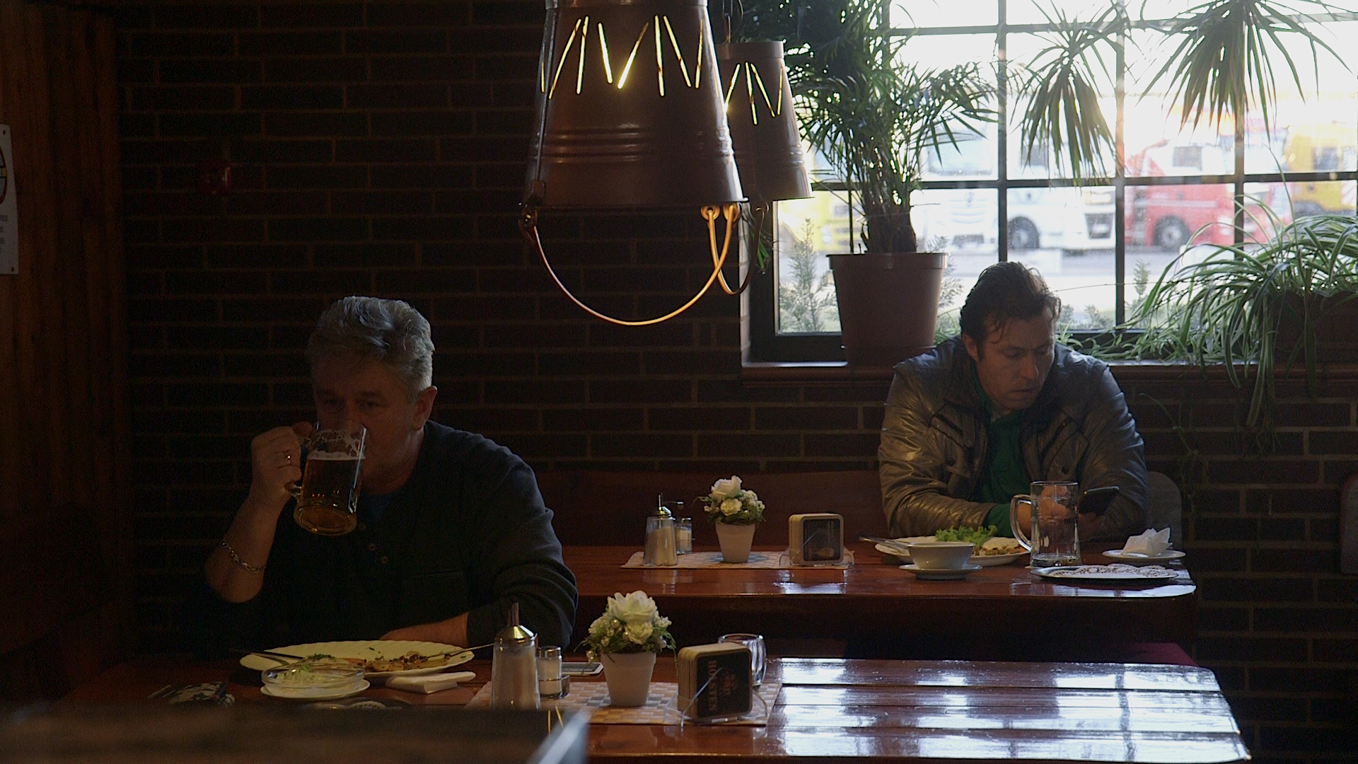 Dos hombres se sientan cada vez sola en una mesa. © NDR