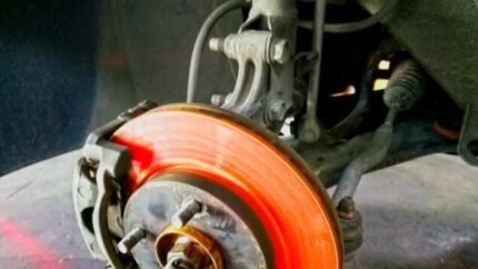 Disco de freno sobrecalentado al rojo vivo durante una frenada intensa.