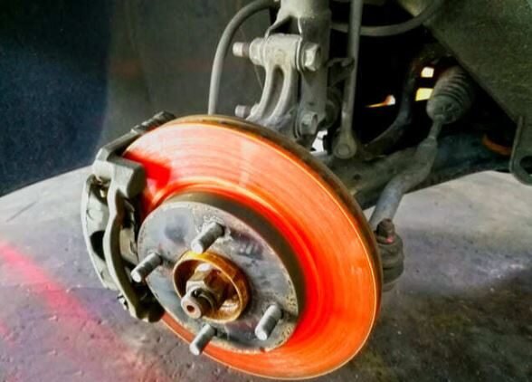 Disco de freno sobrecalentado al rojo vivo durante una frenada intensa.